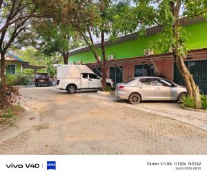 two cars parked in front of a house at ไดซูแนลรีสอร์ท in Ban Nong Song Hong