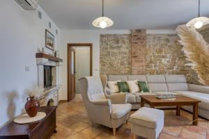 salon z kanapą i kominkiem w obiekcie Villa Ladonja with Private Pool and Sauna w mieście Marasi