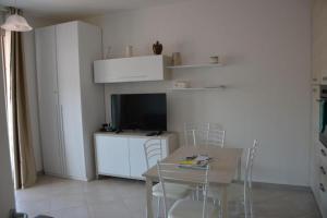 a dining room with a table with chairs and a television at Residenze Carlo Alberto in Castelsardo