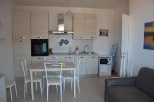 a kitchen and dining room with a table and chairs at Residenze Carlo Alberto in Castelsardo