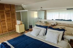 a bedroom with a large bed with blue and white pillows at Bela Vista Chalé in Campos do Jordão