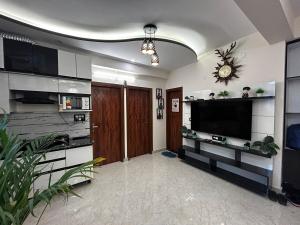 a living room with a flat screen tv on a wall at Casa Cosy NFCDoon in Rājpur