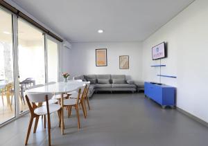 a living room with a table and chairs and a couch at Gjiri i Lalzit - San Pietro - Leta's Apartments with Garden in Lalzit Bay +10 photos