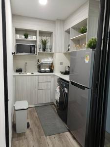 a kitchen with a refrigerator and a sink at Kave Embryo Pathum Thani Luxurious Condo in Ban Lam Phak Kut