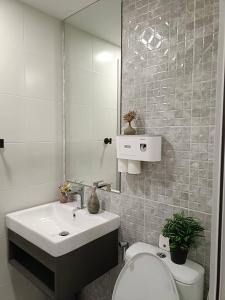 a bathroom with a sink and a toilet and a mirror at Kave Embryo Pathum Thani Luxurious Condo in Ban Lam Phak Kut