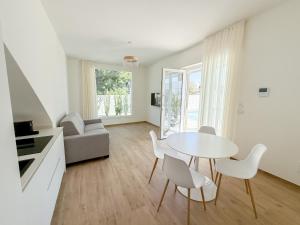 Una sala de estar blanca con una mesa y sillas. en TWINSANDBI Apartments B, en Taranto