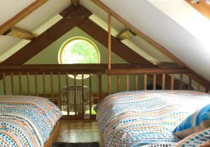 a attic room with two beds and a window at Eco-friendly Cornish sanctuary in Penzance