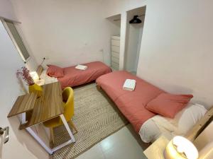 2 Betten in einem kleinen Zimmer mit einem Tisch und einem Stuhl in der Unterkunft Terra - Valle de Ayora in Jalance