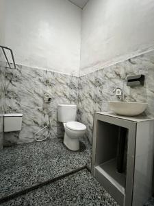 um banheiro com vaso sanitário e pia em Lake Side retreat em Kintamani