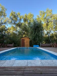 a swimming pool with a wooden hut in a park at Cabaña Magnolia en Marea Delta del Tigre in Tigre