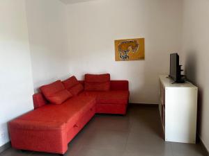a living room with a red couch and a television at ELENA in Conca