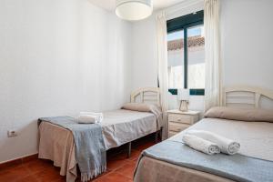 two twin beds in a room with a window at aldea 3 4 1ºB in Novo Sancti Petri +17 photos