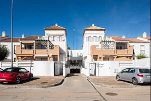 two cars parked in a parking lot in front of a building at aldea 3 4 1ºB in Novo Sancti Petri