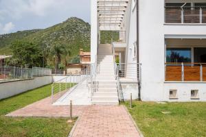 a white building with a staircase in front of it at Lovely Tiresia Apartment in Sperlonga