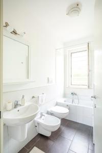 a white bathroom with a sink and a toilet at Lovely Tiresia Apartment in Sperlonga +37 photos