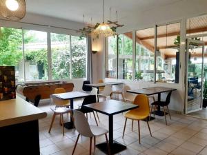 a restaurant with tables and chairs and a pool at ZEcamping 4 étoiles familial avec pataugeoire et jacuzzi in Coulon