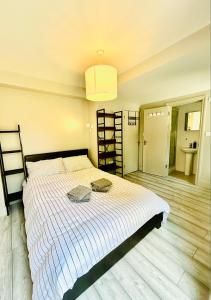 a bedroom with a bed and a bathroom with a sink at Heart of Dalston East London in London
