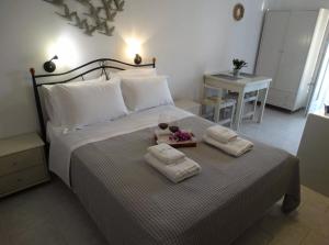 a bedroom with a bed with two towels and two glasses at Castelopetra in Katapola