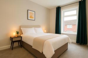 a bedroom with a large bed and a window at 4 Bedroom Spacious House in Cardiff in Cardiff +9 photos