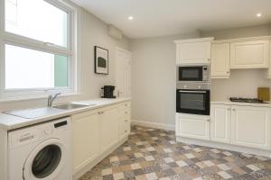 a kitchen with a washing machine and a sink at 4 Bedroom Spacious House in Cardiff in Cardiff