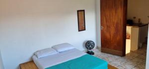 a bedroom with a bed and a fan and a door at O Paraiso é Aqui ! Casa de Hóspedes in Ubatuba