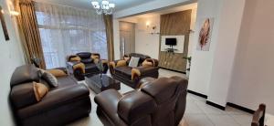 a living room with leather furniture and a television at Gemütliches Zimmer in guter Lage in Addis Ababa