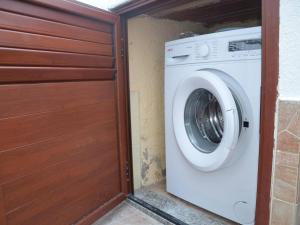 eine Waschmaschine in einem Zimmer mit einer Holztür in der Unterkunft FPO CLA01 fantastic villa sul porto 6 posti letto in Porto Ottiolu