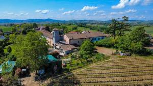 una vista aerea di una casa su una collina accanto a una fattoria di Agriturismo Le Tre Rose - Cantina Zanello a Rosignano Monferrato
