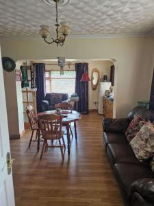 a living room with a table and a couch at The Railway Lodge - 4 Bedrooms Sleeps 11 Pets Ok in Moate