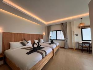 a hotel room with two beds and a table at Prukrom Lanta Villa in Ko Lanta +76 photos