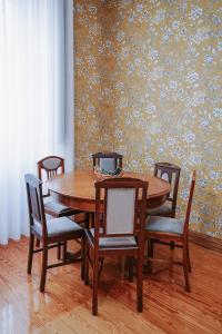 a dining room table and chairs with a wall at Boanova Guesthouse Convento Cucujães in Oliveira de Azemeis