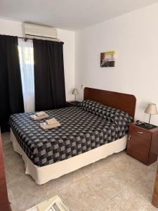 a bedroom with a large bed with black curtains at Cabañas Boulevard in Chascomús +44 photos