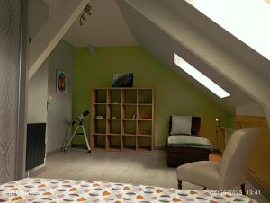 a attic room with a bed and a chair at Maison Sowilo in Préchacq-Josbaig