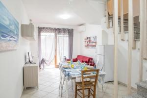 a dining room with a table and chairs at Appartamento su due piani con vista mare in Castelsardo