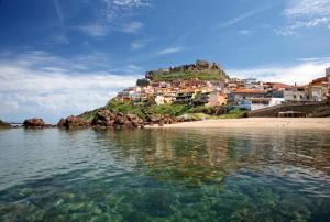 a view of a town on a hill from the water at Appartamento su due piani con vista mare in Castelsardo