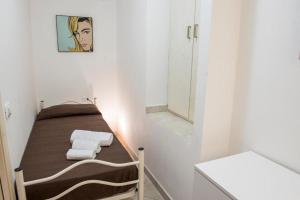 a small bathroom with a bed with towels and a mirror at Appartamento su due piani con vista mare in Castelsardo