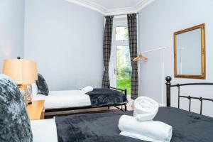 a hotel room with two beds and a mirror at 3BR Home Next to Stadium Near Airport Sleeps 7 in Edinburgh