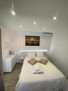 a bedroom with a large white bed with a book on it at Angelica Residence in Gennadi