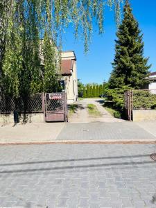 an empty street with a gate and a tree at Noclegi Mosina in Mosina