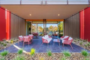 a patio with red chairs and tables and sliding glass doors at Parigina - CaSanGiorgio104 in Medesano
