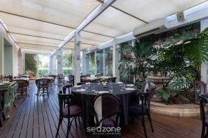 a dining room with tables and chairs and plants at Confortáveis Studios no IL Campanario Resort ILCJR in Florianópolis