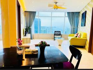 un salon avec une table et un canapé jaune dans l'établissement VorteX KLCC By City Center, à Kuala Lumpur