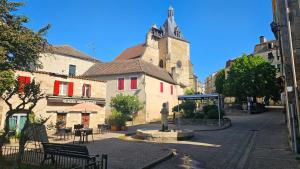 a building with a clock tower on a street at Le "Chic en Ville" Centre historique, climatisé, wifi, Parking sous-sol inclus in Bergerac