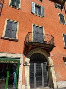 um edifício laranja com uma varanda e uma porta em La terrazza di Vittoria em Verona