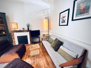 a living room with a couch and a tv at Le JaKadi, Townhouse, Rennes city center in Rennes