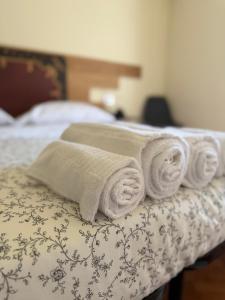 uma pilha de toalhas em cima de uma cama em La terrazza di Vittoria em Verona