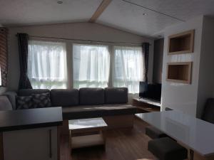 a living room with a couch and a table at Camping Alkenhaer Appelscha Chalet 111 in Appelscha
