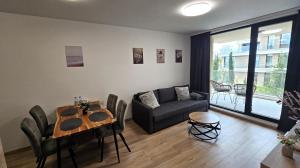 salon ze stołem i kanapą w obiekcie Luxury 2 Room Flat Free Parking, Pool and WiFi w Warnie