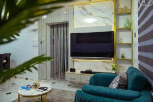 MamaにあるRhaaf Apartmentの青いソファとテレビのあるリビングルーム