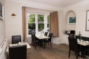a dining room with tables and chairs and a window at Denecrest Guest House in Windermere